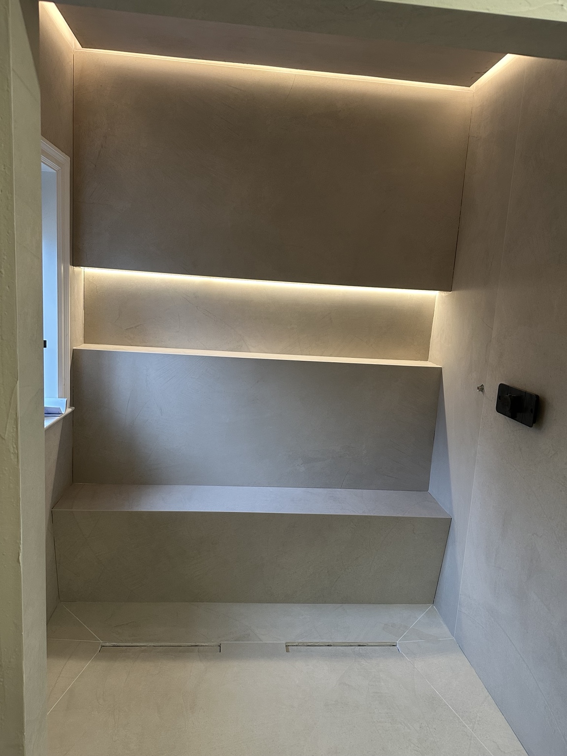Large format tiled shower with illuminated shelving installed by SAS Tiling