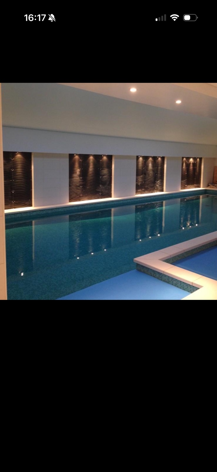 Bespoke tiled feature walls behind indoor swimming pool